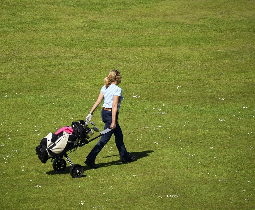 a golfer pulling a cart used to carry a golf bag