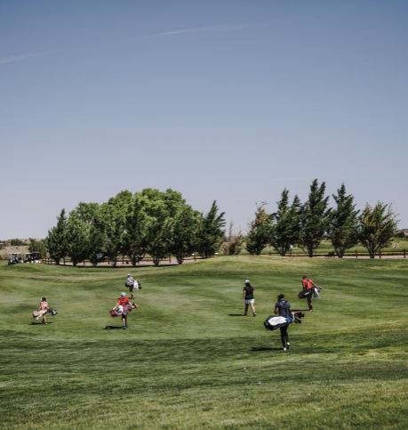 Caddies and golfer walking on the field