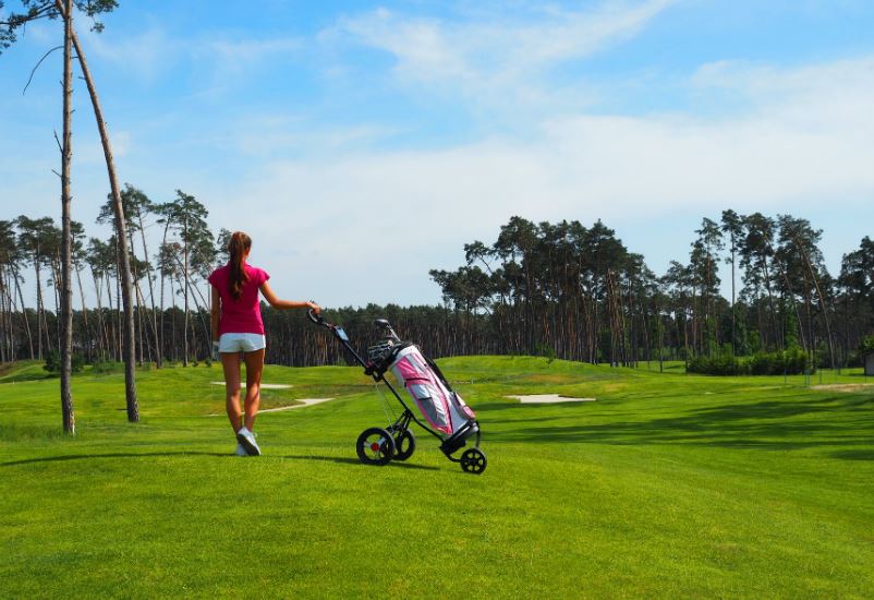 woman walking with a golf bag