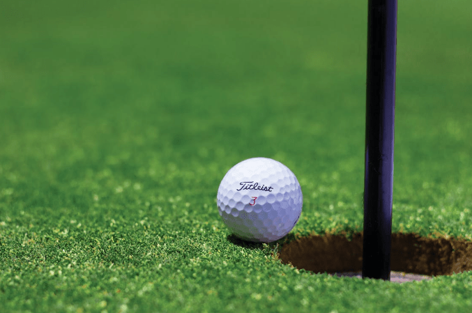titrist-golf-ball-near-golf-hole
