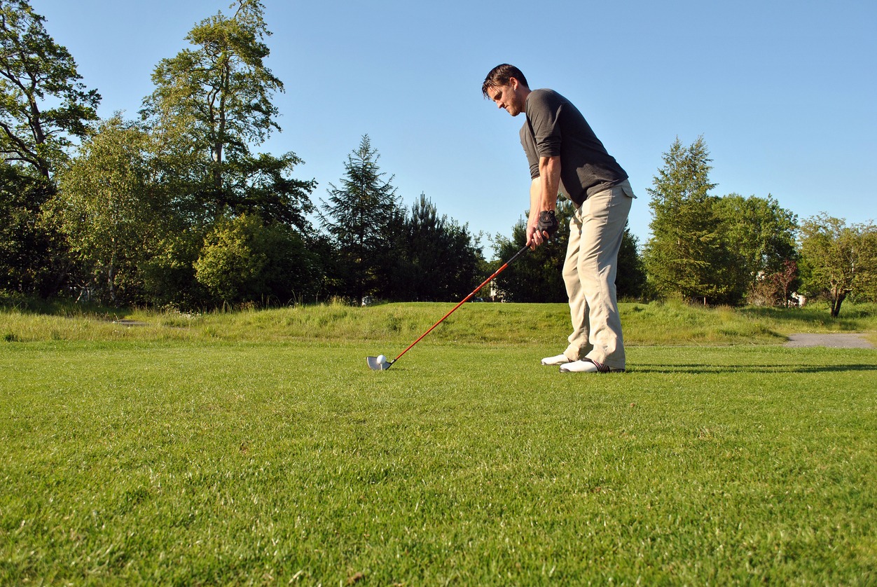 A golfer positioned ready to swing on a golf course