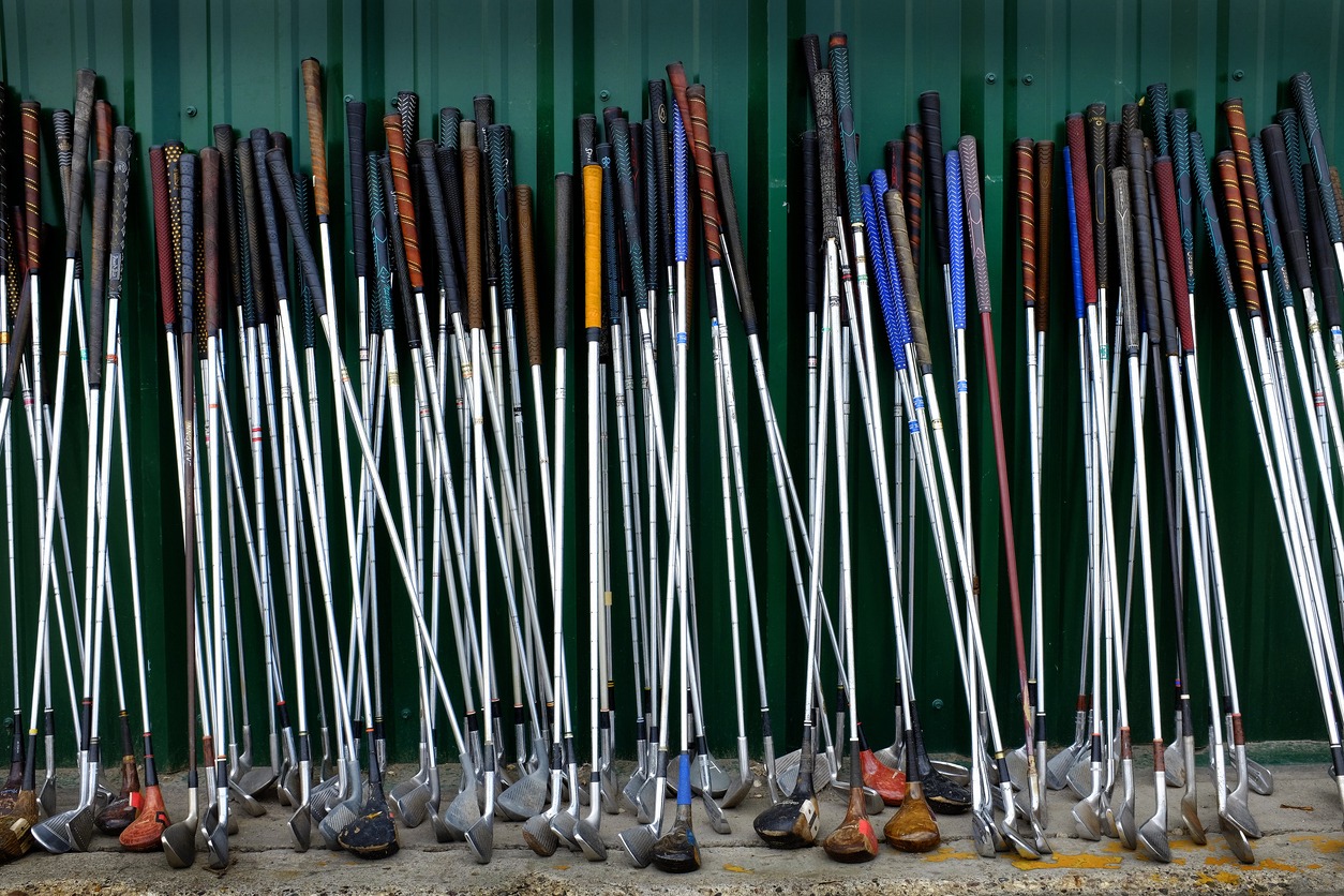 A row of steel-shafted golf clubs