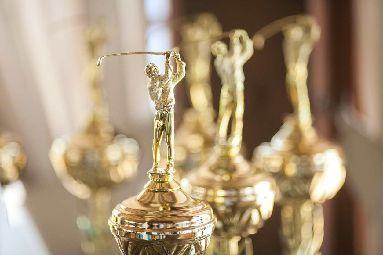 a close up shot of several gold golfing trophies